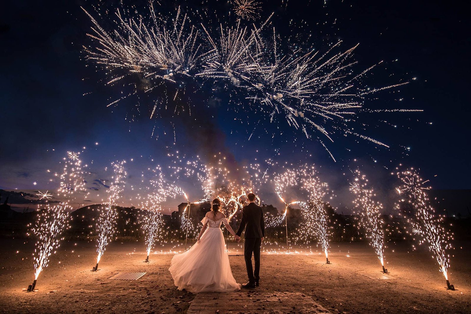 A couple in wedding dresses on the background of fireworks at ni